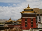 Tibet, Shigatse, Tashilhunpo monastery: The tomb of the 5th to the 9th Panchen Lama on the right and a part of the courtyard and the roof of the tomb of the 4th Panchen Lama from the path to the Thangka wall