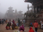 Nepal, Central Region, Bagmati Zone, Lalitpur, Patan, Durbar Square: Streetvendors in the early wintermorning in front of Bhimsen Temple, in the back Garuda statue, Harishankar and Vishnu temple